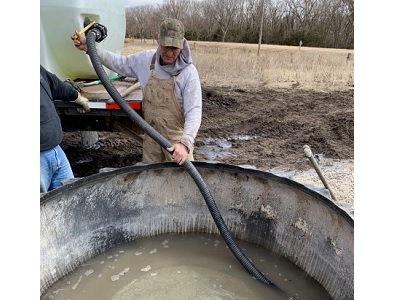 KCARE Watershed Specialist Herschel George fills a newly installed tire tank at the Corley farm in Russell County.
